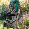 Drive Rollator Nitro met zachte banden in champagne, gebruikt buiten op tuinpad voor stabiel en comfortabel lopen