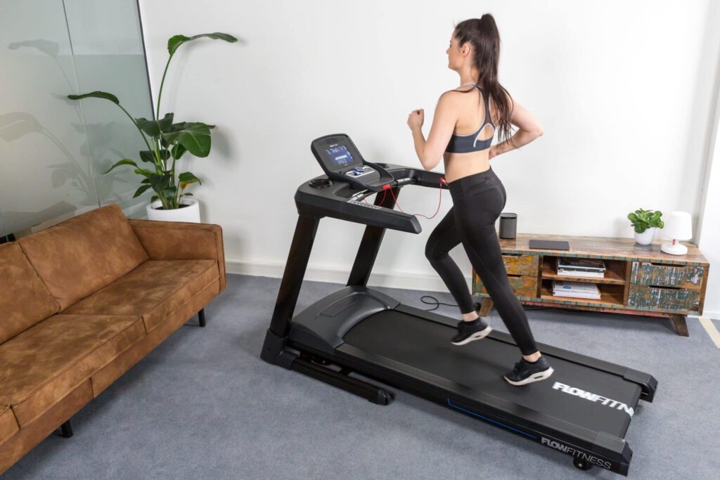 Loopband T2i van het merk Flow Fitness geschikt tot 180 kg. voorbeeld vrouw computer bedienen