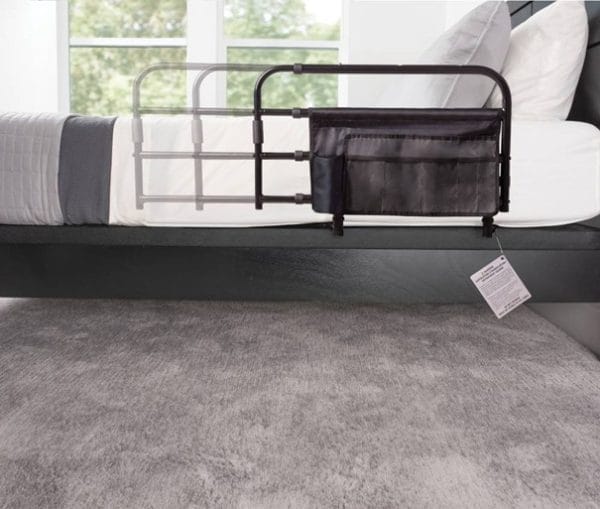 In lengte verstelbaar sta-op hulp bedhek Pivot-rail met opberghoes gemonteerd aan zijkant van boxspringbed.