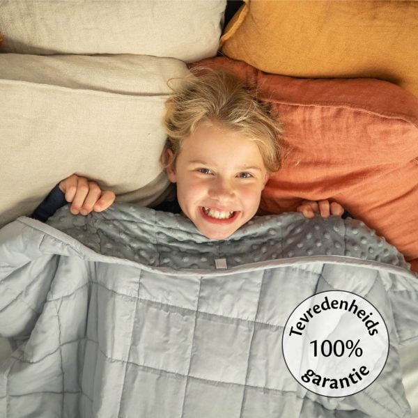 Verzwaringsdeken voor kinder van Thuiszorgwinkel.nl met een meisje onder de dekens lachend
