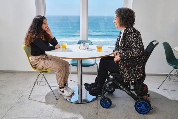 Quickie Q50 R Carbon de lichtste elektrische rolstoel, voorbeeld vrouw aan tafel