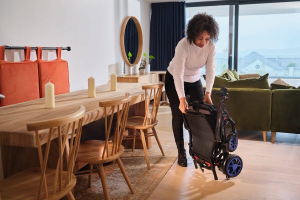 Quickie Q50 R Carbon de lichtste elektrische rolstoel, voorbeeld vrouw klapt de rolstoel in