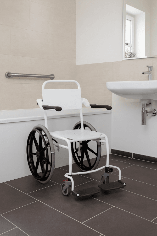 Douche rolstoel in moderne, drempelloze badkamer met steunbeugel en wastafel – ideaal voor veilige en comfortabele persoonlijke verzorging.