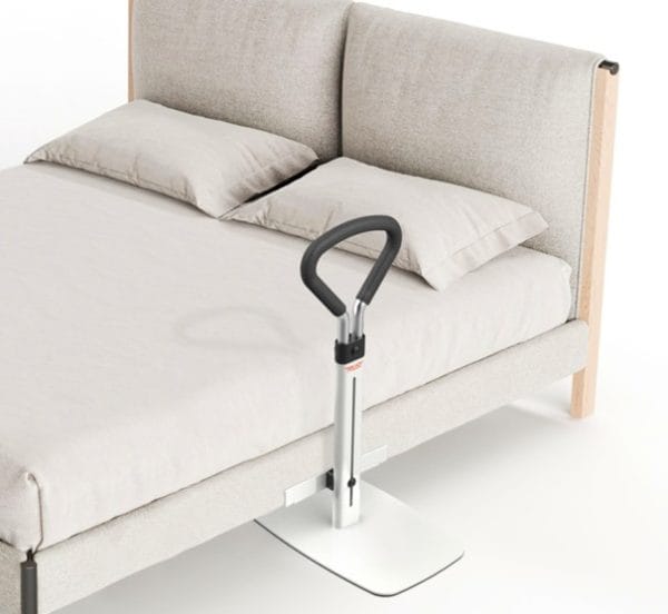 Sta-ophulp Let's Get Up bedbeugel naast lichtgrijs tweepersoonsbed voor veilig in en uit bed stappen.