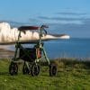 De Trive All Terrain rollator van Uplivin staat in een natuurlijke omgeving met uitzicht op zee. Deze rollator is ontworpen voor vrijheid en vertrouwen, ideaal voor wandelingen op zowel verharde als onverharde paden.