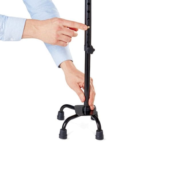 Close-up van Vitility Wandelstok Quadro vierpoot; hand stelt de hoogte af via verstelgaten voor stabiel gebruik.