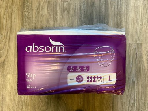 Paarse verpakking Absorin Slip Night incontinentieslips maat L op houten vloer