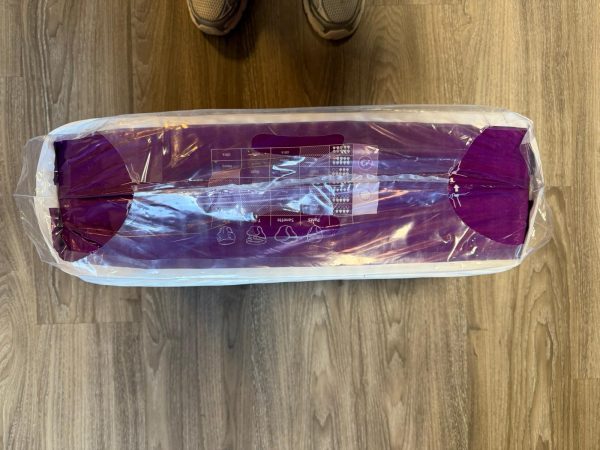 Bovenzijde van een opengescheurde paarse verpakking Absorin Comfort Slip Day/Night Large op houten vloer