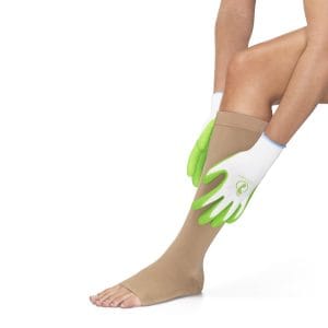 Latexvrije Steve griphandschoenen in groen-wit bij het aantrekken van een beige steunkous