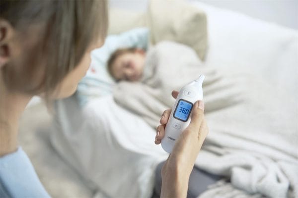 Oorthermometer OMRON Gentle Temp 533 meet koorts bij kind in bed, display toont 38,0 °C