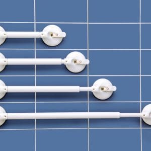 Mobeli verstelbare wandbeugel met zuignap in vier lengtes op blauwe badkamertegelwand voor extra steun bij toilet en douche.