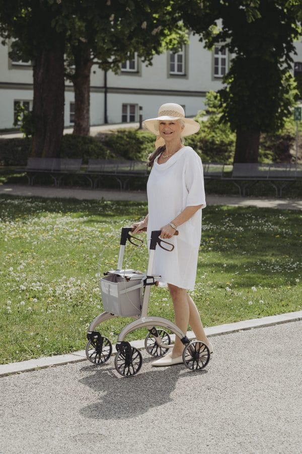 Saljol carbon rollator Superlight in champagnekleur tijdens een wandeling in het park, licht en wendbaar in gebruik