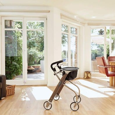 Smalle binnenrollator Let’s Dream met dienblad en mandje in een lichte woonkamer.