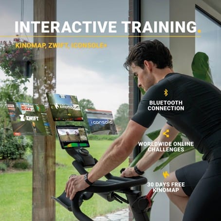 Man traint thuis op een zwarte Flow Fitness Perform S2i spinningfiets met Bluetooth-koppeling naar Kinomap, Zwift en iConsole+